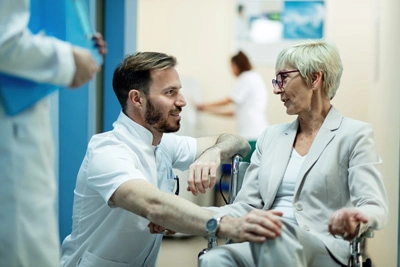 senior-woman-wheelchair-mid-adult-doctor-talking-hallway-hospital
